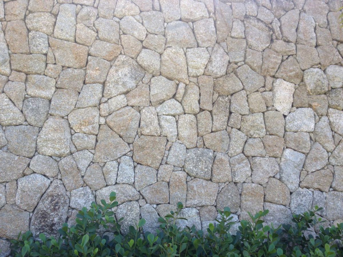 6. Muro pequeno de pedra do mato (moledo) com acabamento rustico, sendo  pedras boleadas nas laterais. Em cima foi feito um espaç…